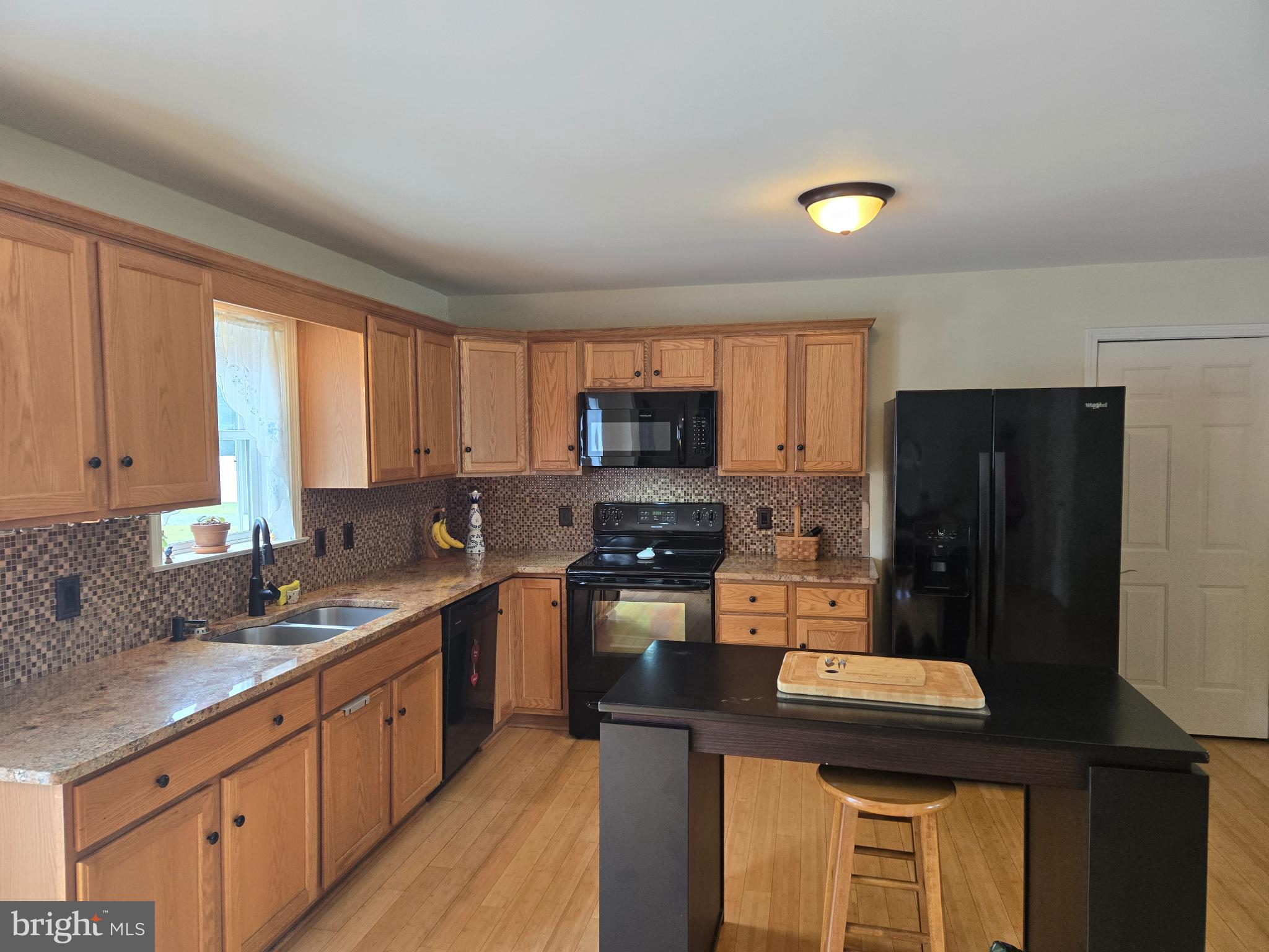 18453 Joseph Road Milton, DE 19968 - Photo 9 of 49 a kitchen with a sink a stove a refrigerator cabinets and a window