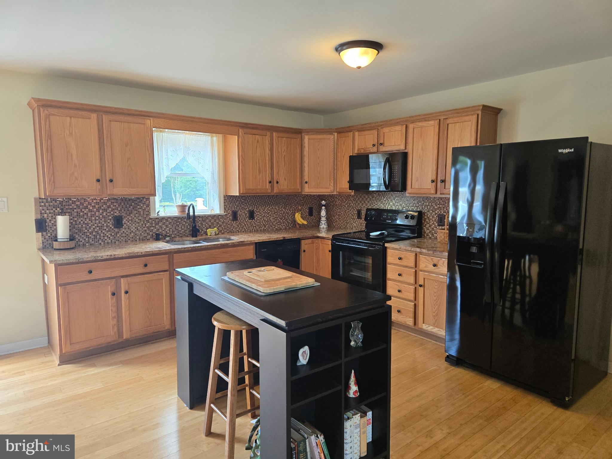 18453 Joseph Road Milton, DE 19968 - Photo 10 of 49 a kitchen with stainless steel appliances granite countertop a refrigerator a sink dishwasher a stove with wooden cabinets and floor
