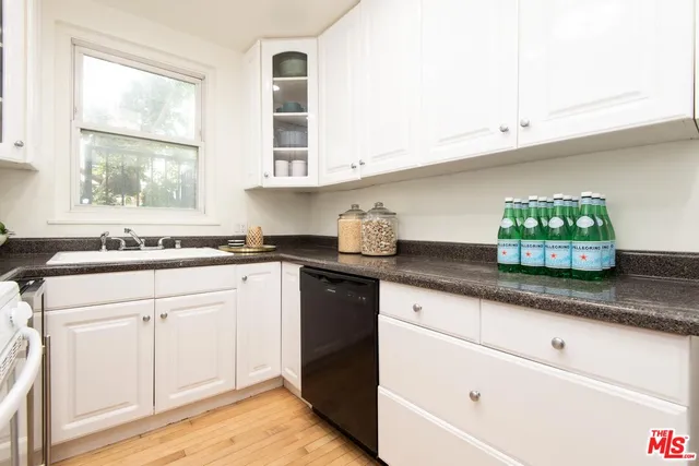 a kitchen with stainless steel appliances white cabinets and a sink
