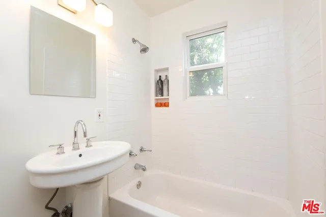 a bathroom with a sink a window and a mirror