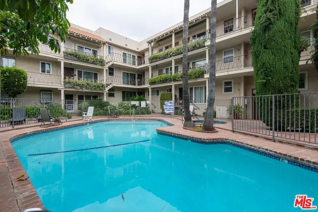 a view of house with swimming pool and outdoor seating