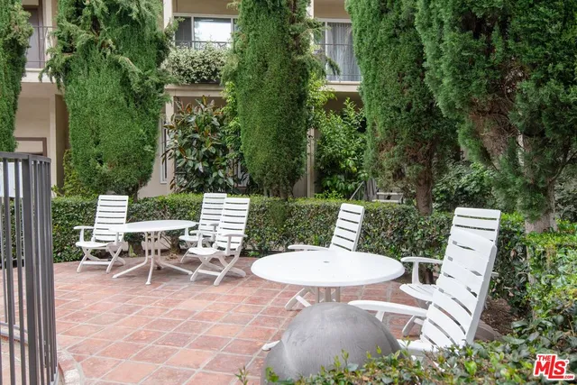 a view of a patio with table and chairs and potted plants