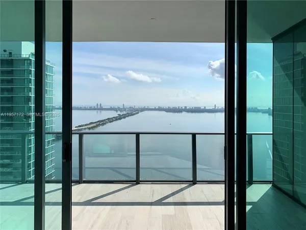 a view of a balcony with a floor to ceiling window and wooden floor