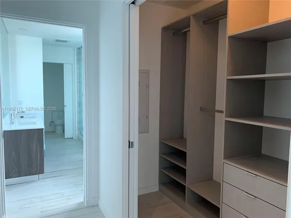 a view of an empty room with wooden floor and floor to ceiling window