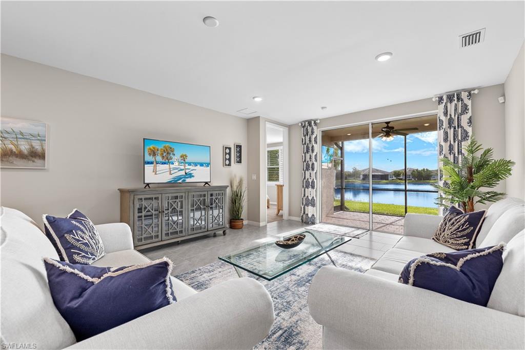 a living room with furniture and a floor to ceiling window