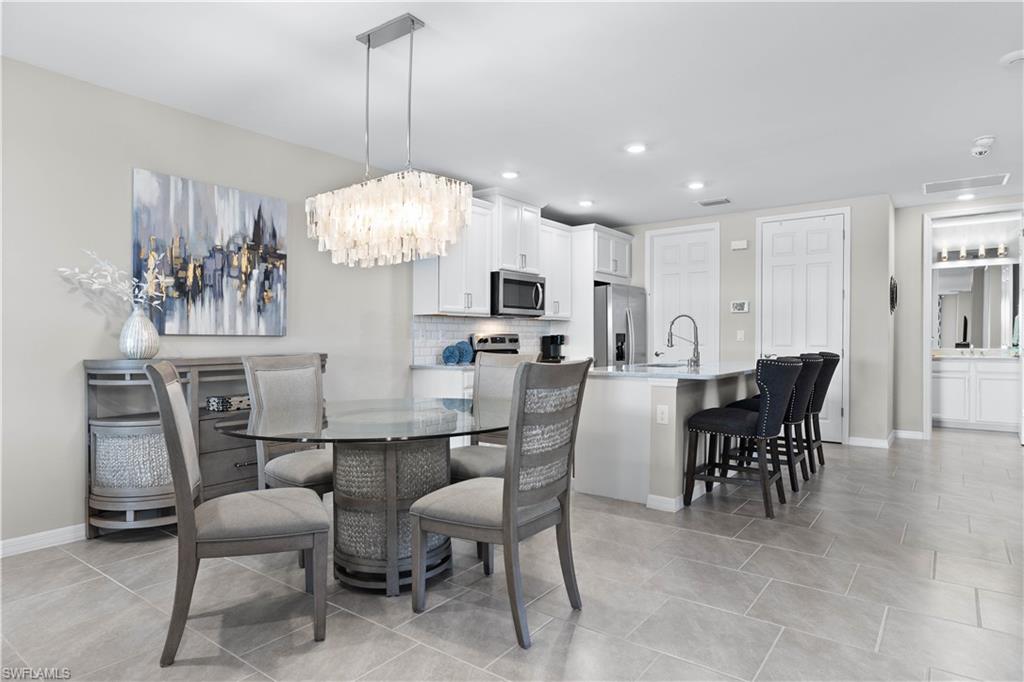 14558 Edgewater Circle Naples, FL 34114 - Photo 11 of 33 a view of a dining room with furniture and chandelier