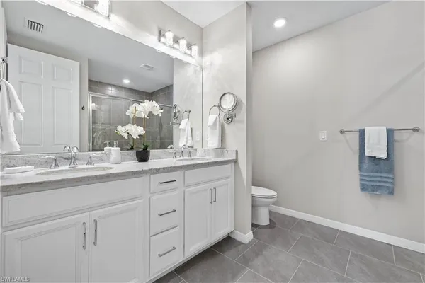 a bathroom with a double vanity sink and a toilet