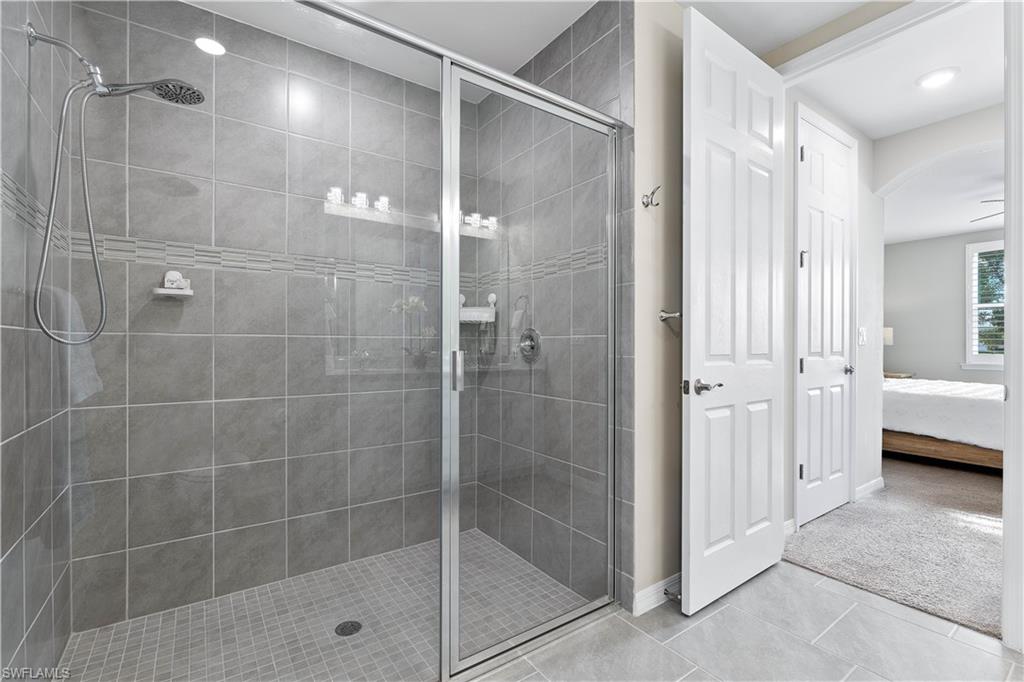 14558 Edgewater Circle Naples, FL 34114 - Photo 16 of 33 a bathroom with a glass shower door