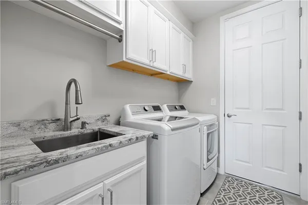 a utility room with sink dryer and washer