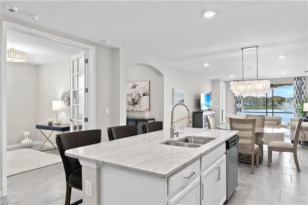 a kitchen with a table chairs and white cabinets