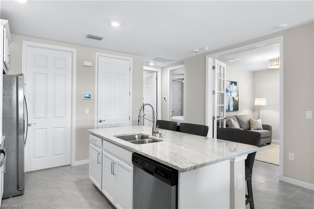 14558 Edgewater Circle Naples, FL 34114 - Photo 9 of 33 a kitchen with a sink and cabinets