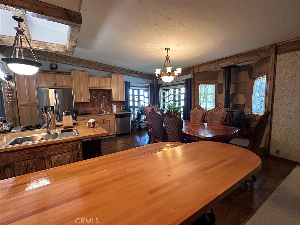 57260 Ramsey Road Anza, CA 92539 - Photo 24 of 46 a large kitchen with kitchen island a sink a stove and a dining table view