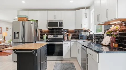 a kitchen with stainless steel appliances granite countertop a sink stove and refrigerator