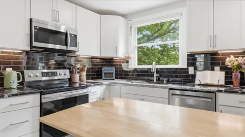 a kitchen with stainless steel appliances a stove sink microwave and cabinets