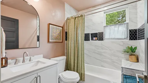a bathroom with a granite countertop sink a toilet a mirror a vanity and shower