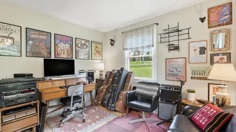 a living room with furniture a flat screen tv and a floor to ceiling window