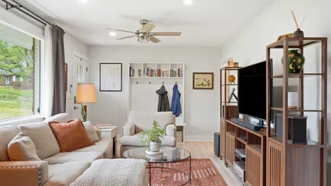 a living room with furniture a window and a flat screen tv