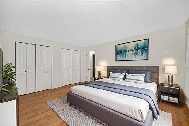 a bedroom with a bed and a painting on the wall