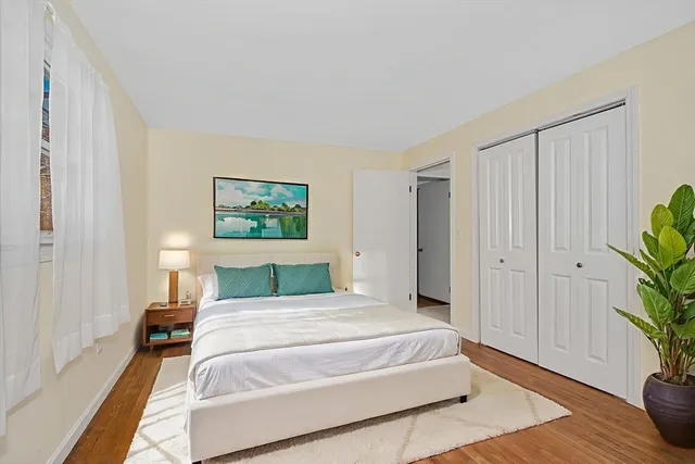a bedroom with a large bed and a potted plant