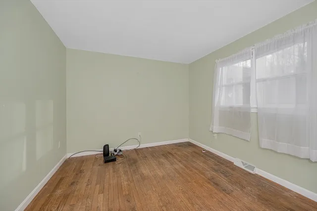 a view of a room with wooden floor and a window