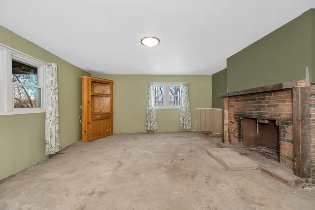 a view of an empty room with a fireplace and a window