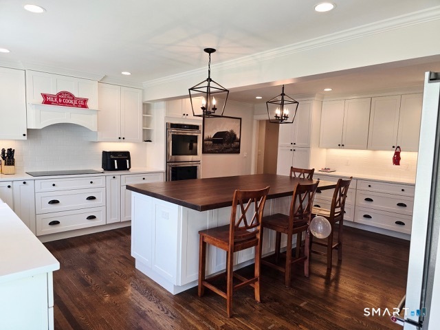 441 David Court Orange, CT 06477 - Photo 14 of 24 a kitchen with stainless steel appliances kitchen island granite countertop a table chairs and a refrigerator