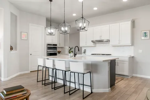 a kitchen with kitchen island granite countertop a sink a center island and cabinets