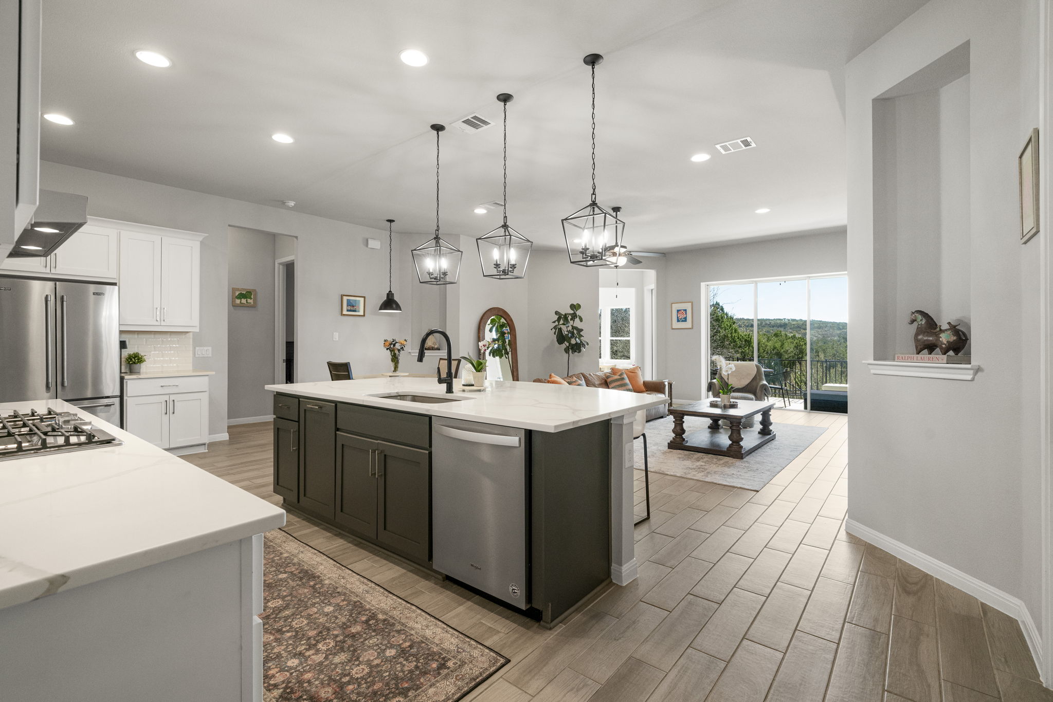 546 Hazy Hills Loop Dripping Springs, TX 78620 - Photo 20 of 40 Features include custom cabinetry, subway tile backsplash, quartz counters, stainless steel appliances, and pendant lighting.