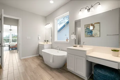 a spacious bathroom with a double vanity sink a mirror and a bathtub
