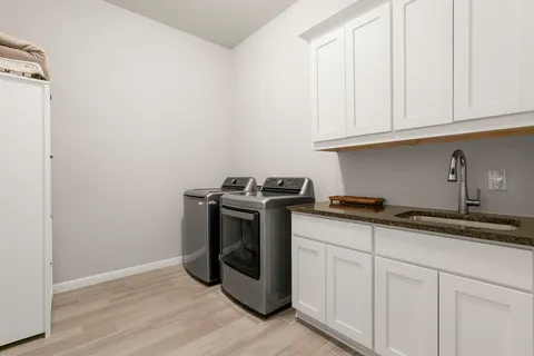 a kitchen with granite countertop white cabinets and stainless steel appliances