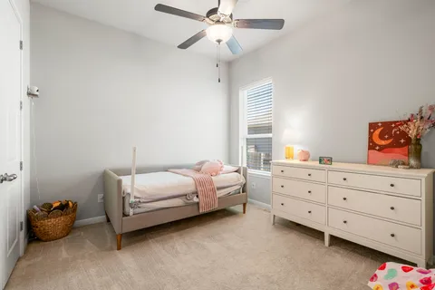 a bedroom with furniture and a chandelier fan