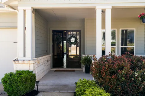 a view of a house with chairs and potted plants
