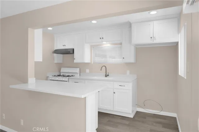 a kitchen with a sink a stove and cabinets