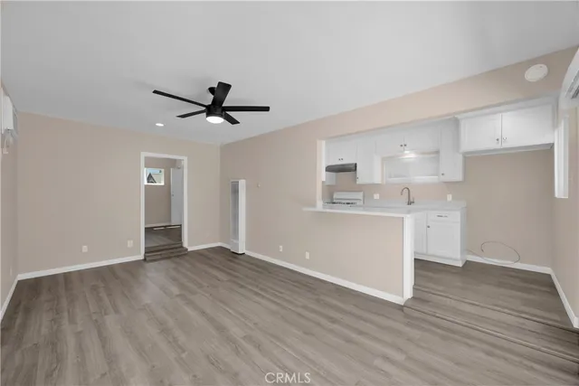a view of a kitchen with wooden floor and a ceiling fan