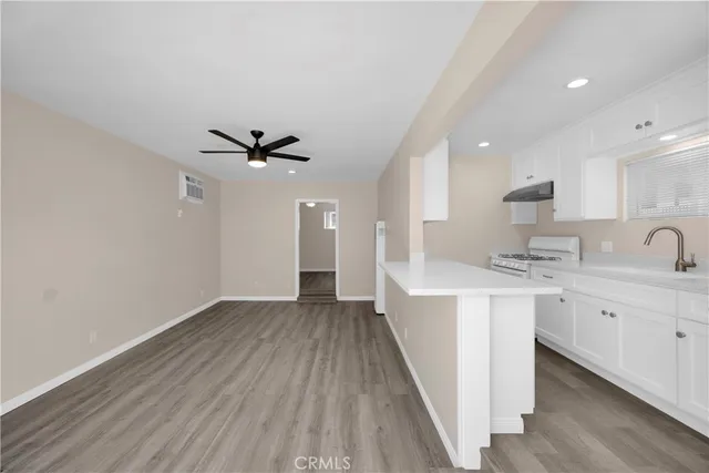 a view of a kitchen with sink and wooden floor