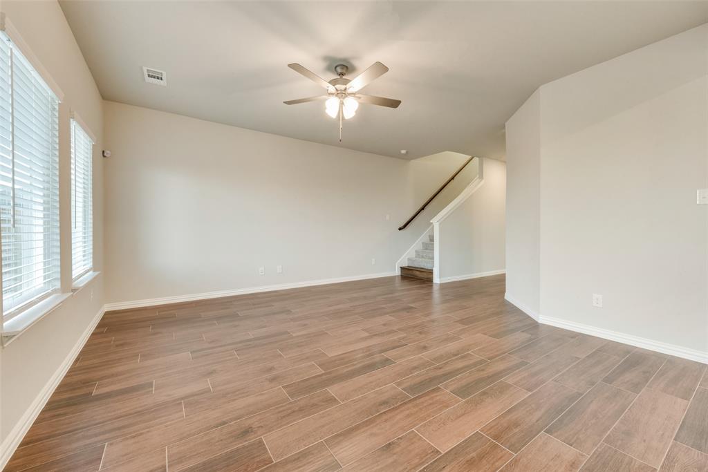 244 Sutter Mill Road Saginaw, TX 76131 - Photo 8 of 21 an empty room with wooden floor and windows