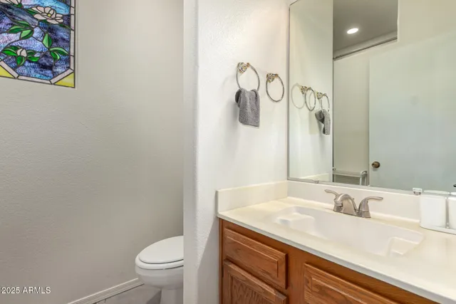 a bathroom with a granite countertop sink a toilet and a mirror