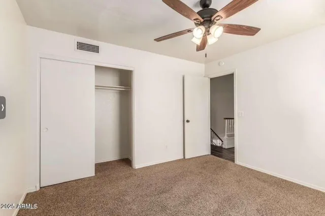 a furnished livingroom with a ceiling fan