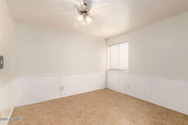 an empty room with a window and ceiling fan
