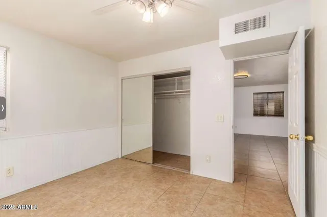 a view of a big room with closet and chandelier fan