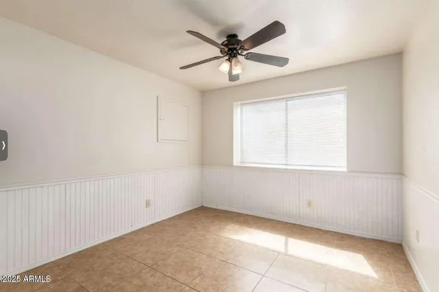 an empty room with a window and a fan