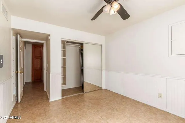a view of a room with a ceiling fan and closet