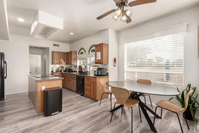 a kitchen with a table chairs refrigerator and cabinets