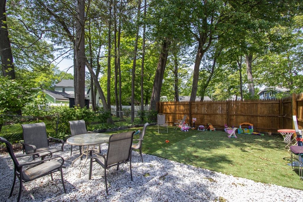 34 Preston Street Springfield, MA 01109 - Photo 33 of 34 a view of a backyard with table and chairs and potted plants and large trees