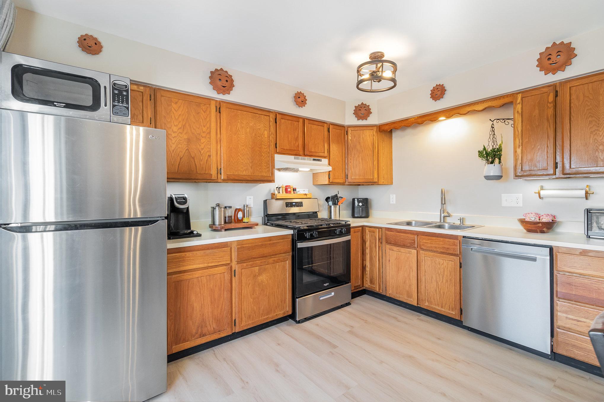 48 Tory Circle Enola, PA 17025 - Photo 8 of 26 a kitchen with stainless steel appliances granite countertop a refrigerator a sink dishwasher a stove top oven a refrigerator and island with wooden floor