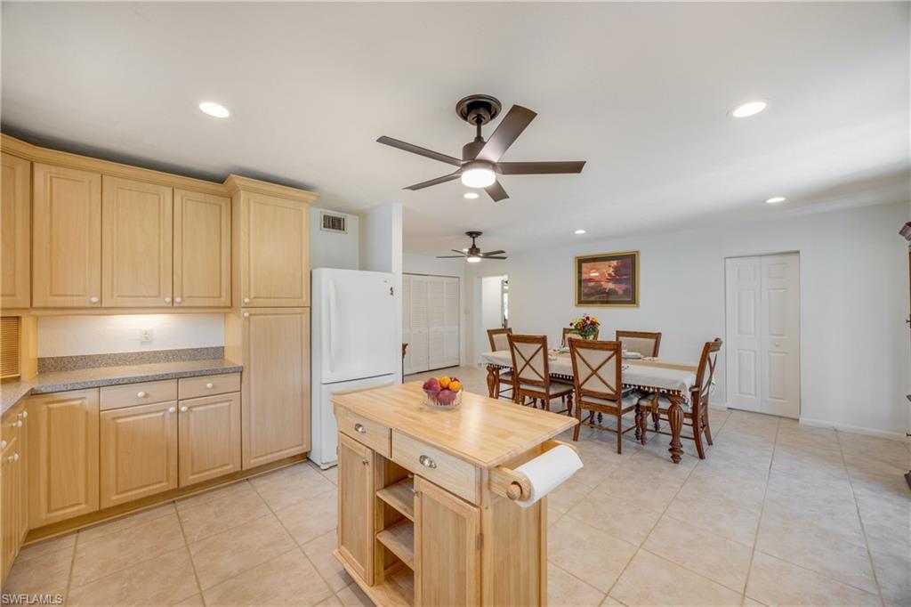 736 92nd Avenue North Naples, FL 34108 - Photo 11 of 25 a open kitchen with stainless steel appliances kitchen island a table in it and white cabinets