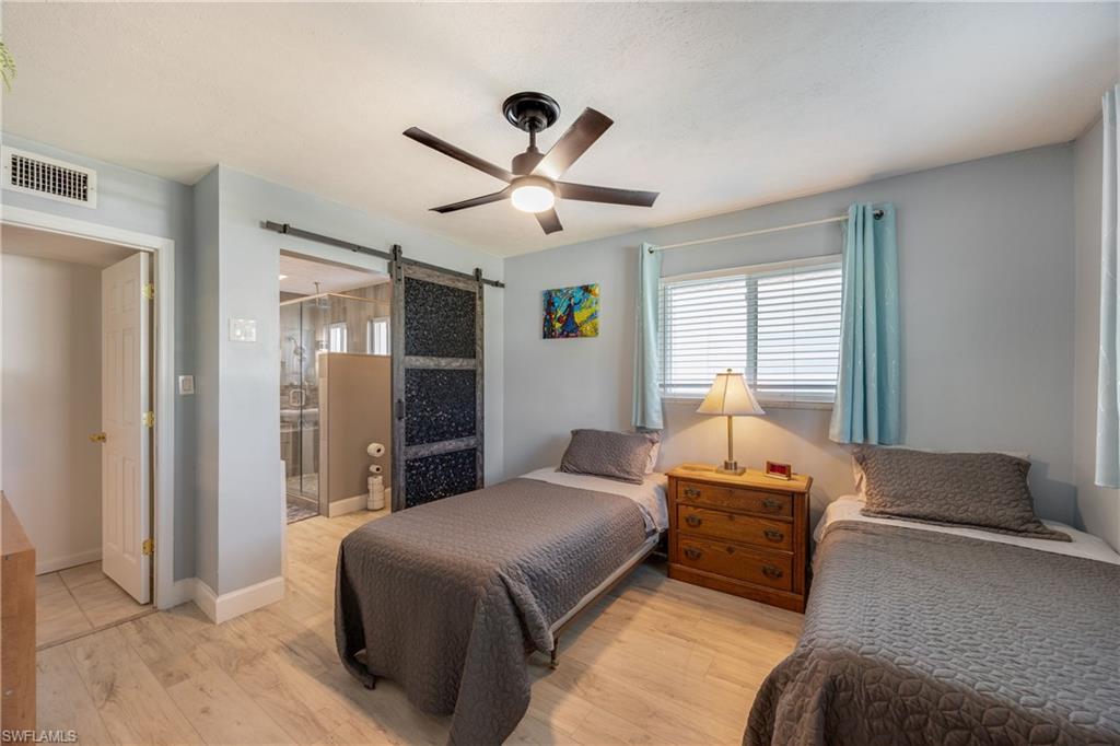 736 92nd Avenue North Naples, FL 34108 - Photo 19 of 25 a bedroom with a bed and a chandelier