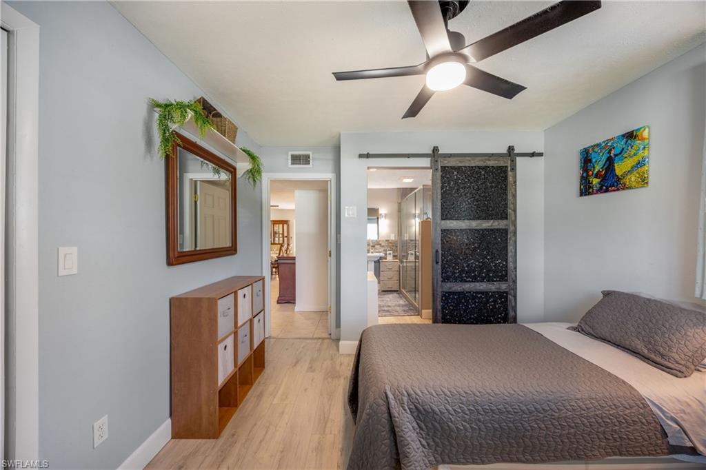 736 92nd Avenue North Naples, FL 34108 - Photo 20 of 25 a bedroom with a bed and a chandelier