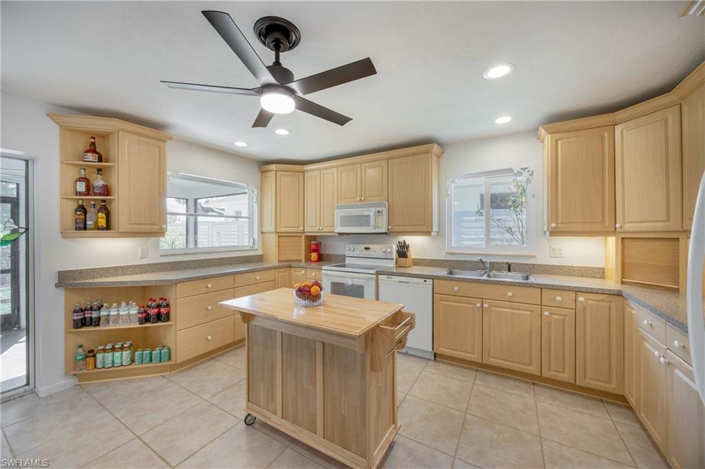 736 92nd Avenue North Naples, FL 34108 - Photo 9 of 25 a kitchen with a stove a sink and a refrigerator