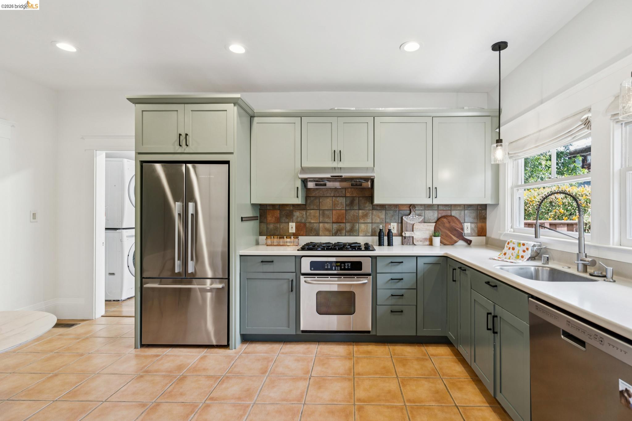 1701 Derby Street Berkeley, CA 94703 - Photo 19 of 39 Modern kitchen featuring two-tone cabinetry, stainless steel appliances, and a tiled backsplash